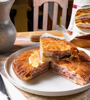 Hornazo de Salamanca dorado y crujiente, con relleno de chorizo, lomo y jamón, servido en tabla de madera