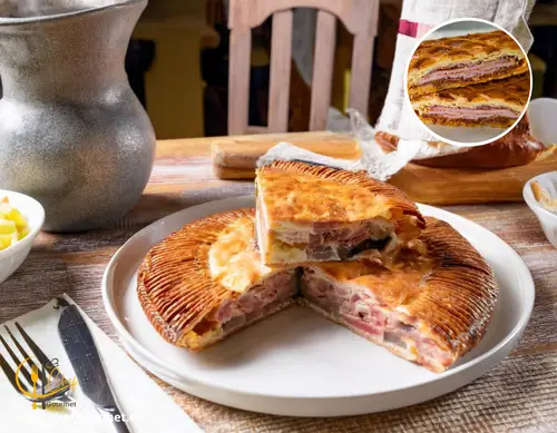 Hornazo de Salamanca dorado y crujiente, con relleno de chorizo, lomo y jamón, servido en tabla de madera