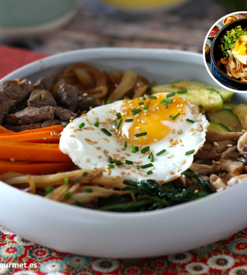 Bol de bibimbap coreano con arroz blanco, espinacas, zanahoria, calabacín, carne salteada y huevo frito, decorado con salsa picante gochujang
