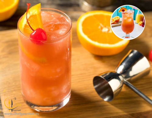 Cóctel Sex on the Beach en vaso alto con hielo, mezcla de vodka, licor de melocotón, zumo de naranja y arándano, decorado con naranja y cereza
