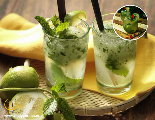 Cóctel Mojito en vaso alto con ron blanco, lima troceada, hojas de menta, hielo y soda, decorado con menta fresca