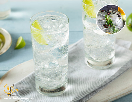 Cóctel Gin Tonic en copa balón con hielo, ginebra, tónica, rodaja de lima y bayas de enebro