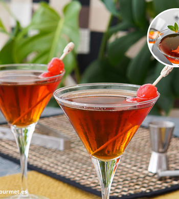 Cóctel Manhattan en copa de cóctel, mezcla de whisky, vermut rojo y angostura, decorado con cereza
