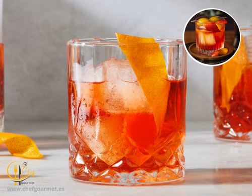 Cóctel Negroni servido en vaso bajo con hielo, mezcla de ginebra, vermut rojo y Campari, decorado con una rodaja de naranja